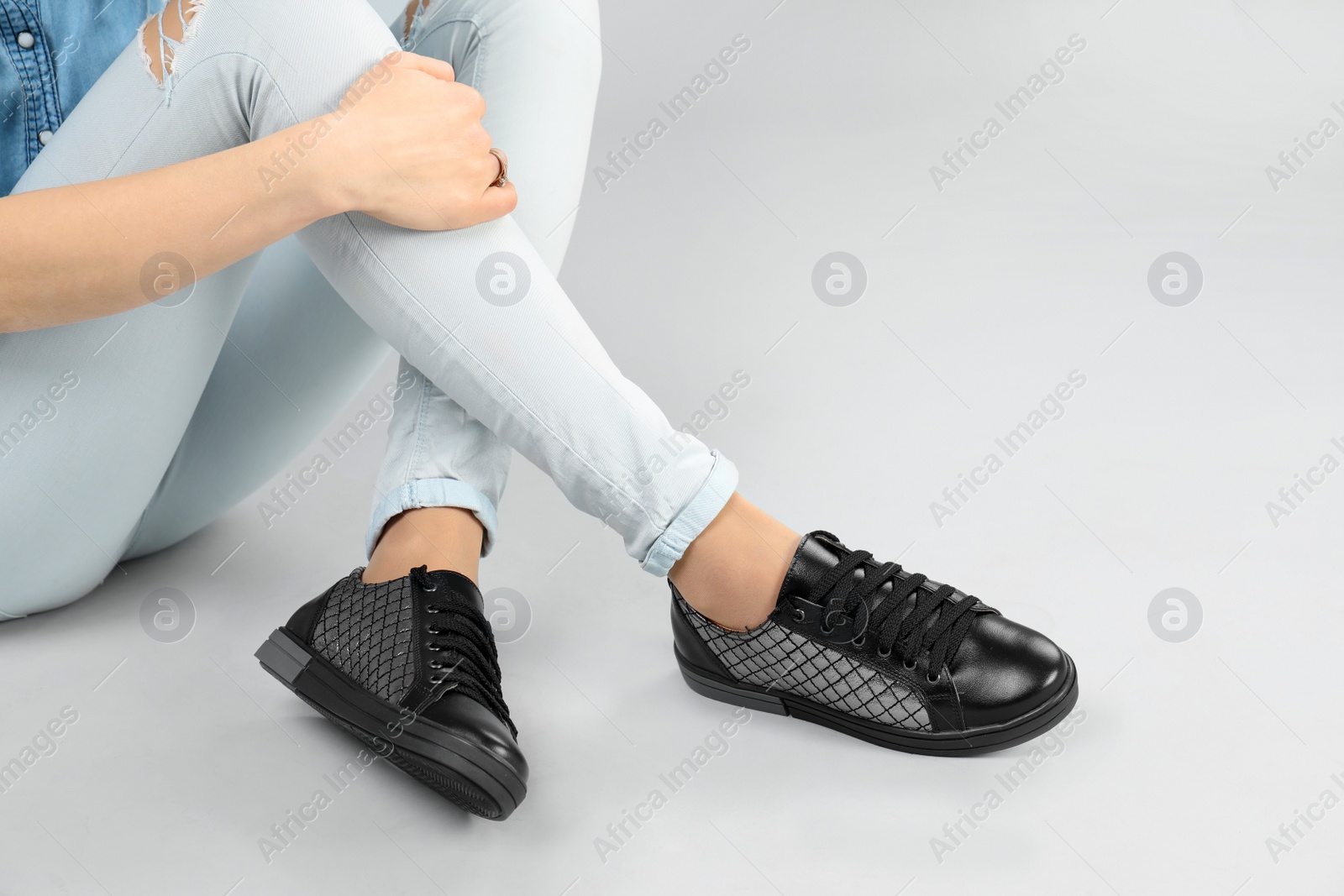 Photo of Woman in stylish shoes on grey background, closeup