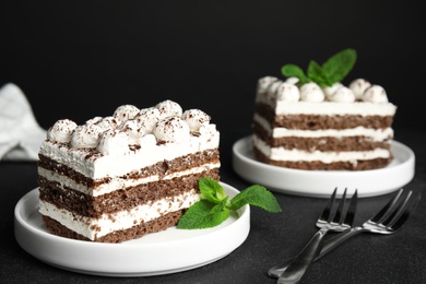 Photo of Delicious tiramisu cakes with mint on table