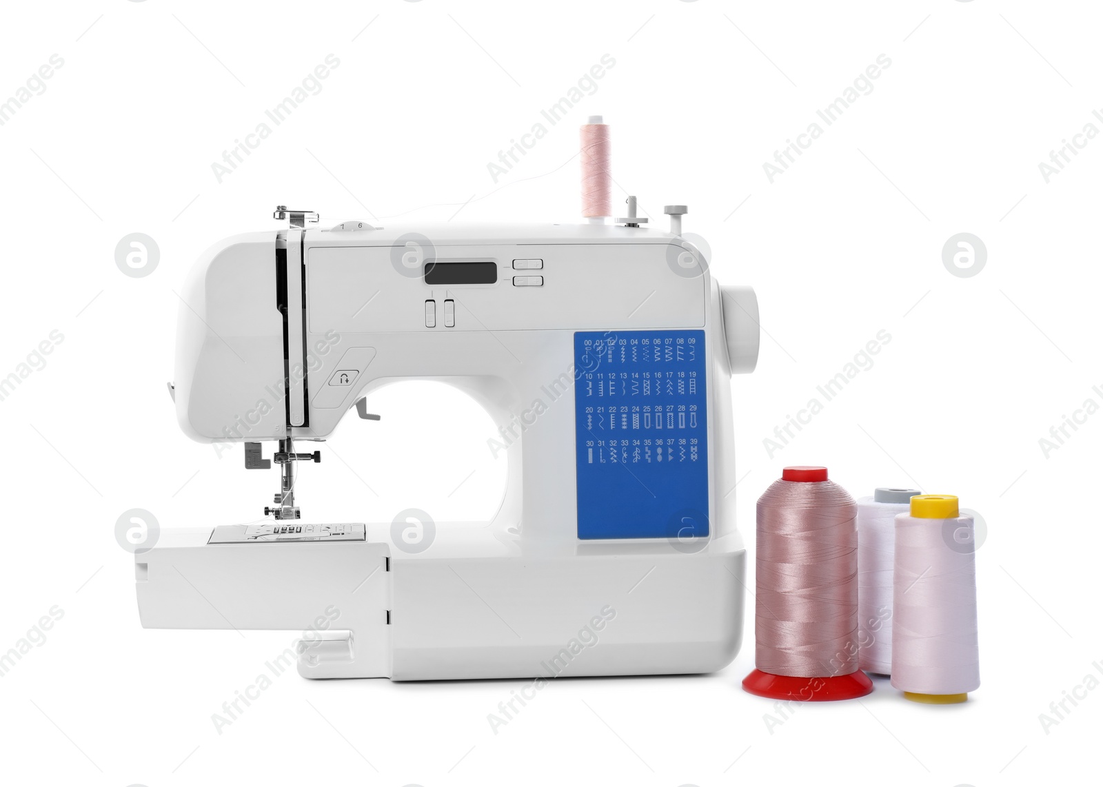 Photo of Sewing machine and spools of threads isolated on white