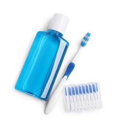 Photo of Fresh mouthwash in bottle, toothbrush and interdental brushes isolated on white, top view