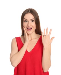 Photo of Emotional young woman wearing beautiful engagement ring on white background