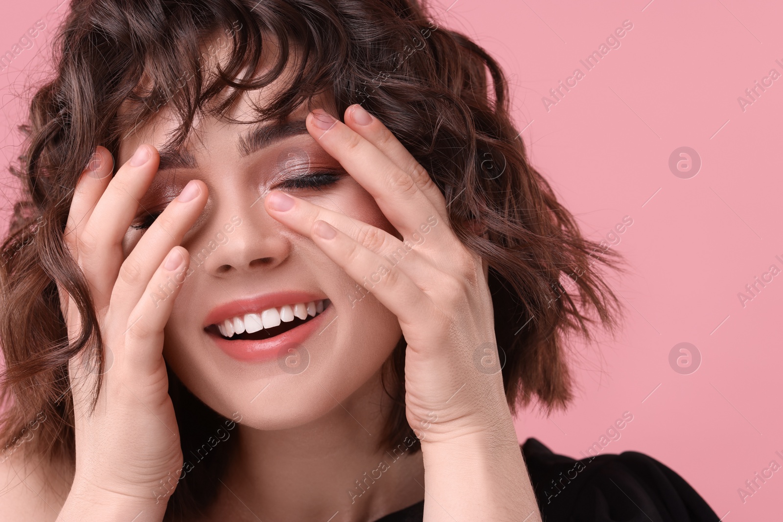 Photo of Beautiful young woman with wavy hairstyle on pink background. Space for text