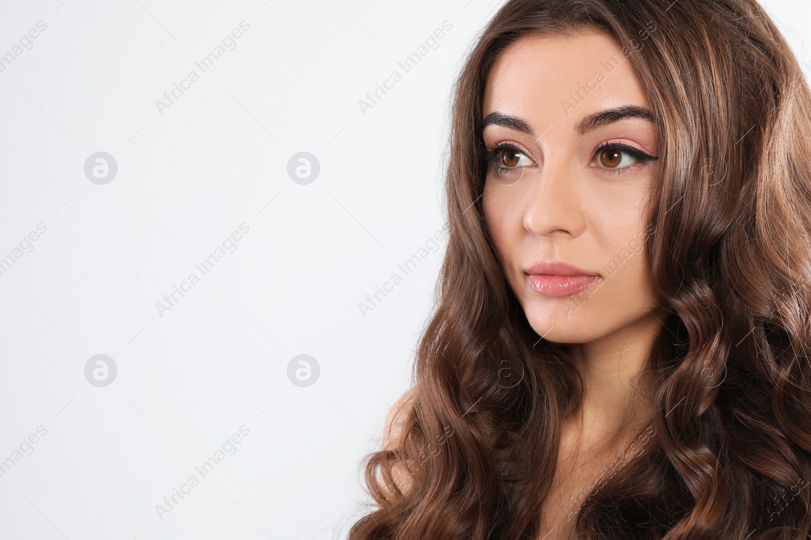 Photo of Beautiful woman with shiny wavy hair on white background. Space for text