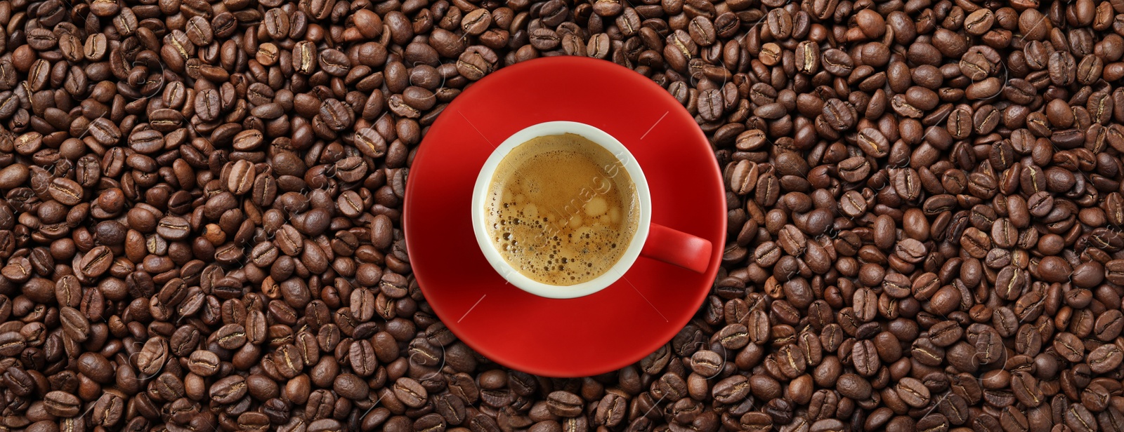 Image of Cup of tasty aromatic coffee on roasted beans, top view. Banner design