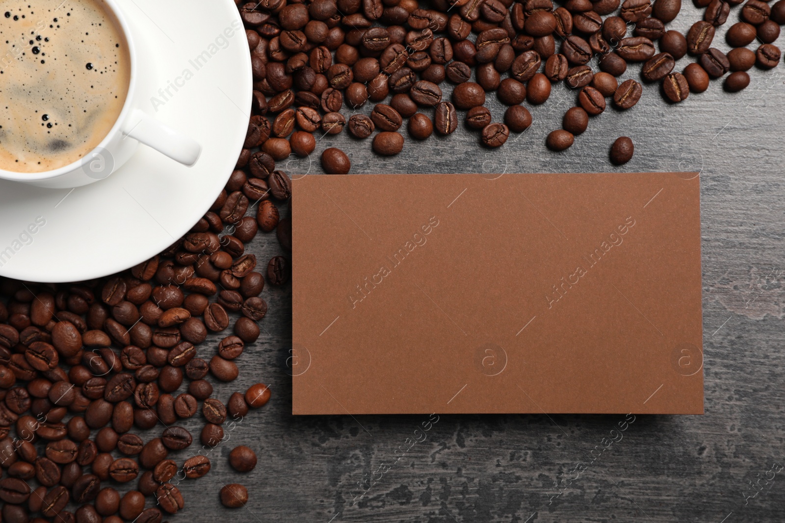 Photo of Card, beans and cup of hot drink on dark table, flat lay. Coffee break