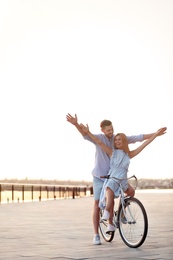 Photo of Happy couple riding bicycle outdoors on summer day