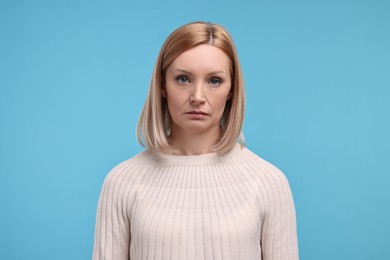 Photo of Portrait of sad woman on light blue background