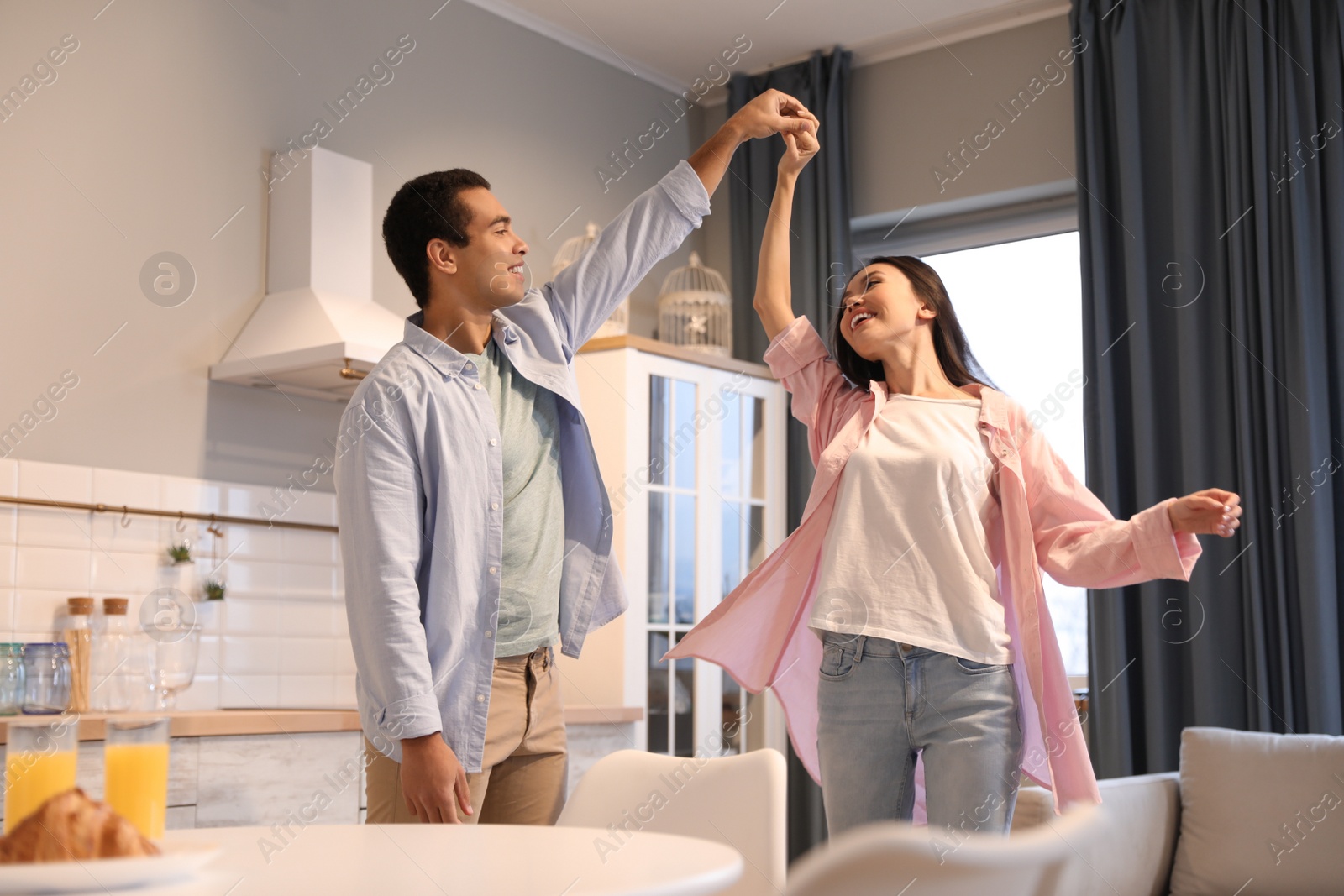 Photo of Lovely young interracial couple dancing at home