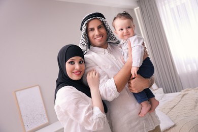 Photo of Happy Muslim family with little son in bedroom