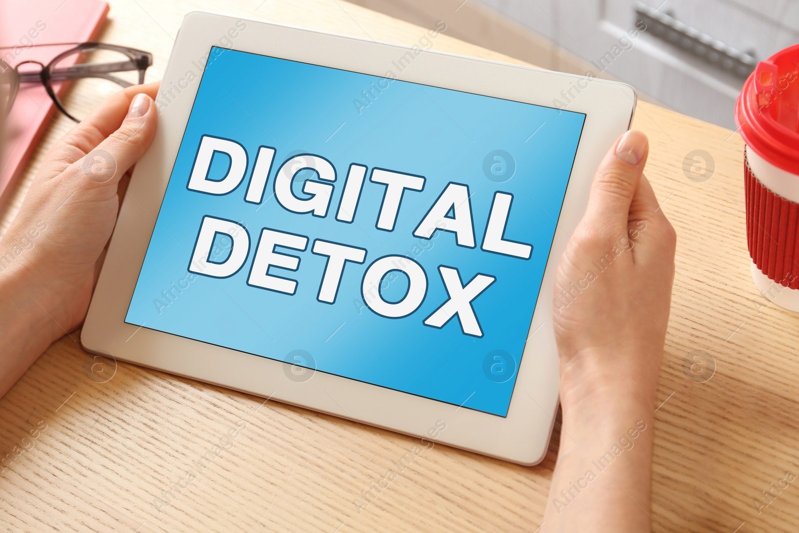 Image of Woman using tablet computer with text Digital Detox at table, closeup