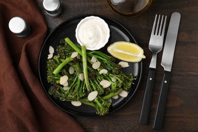 Photo of Tasty cooked broccolini served on wooden table, flat lay
