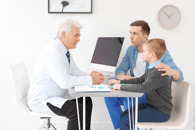 Young man with his son having appointment at child psychologist office
