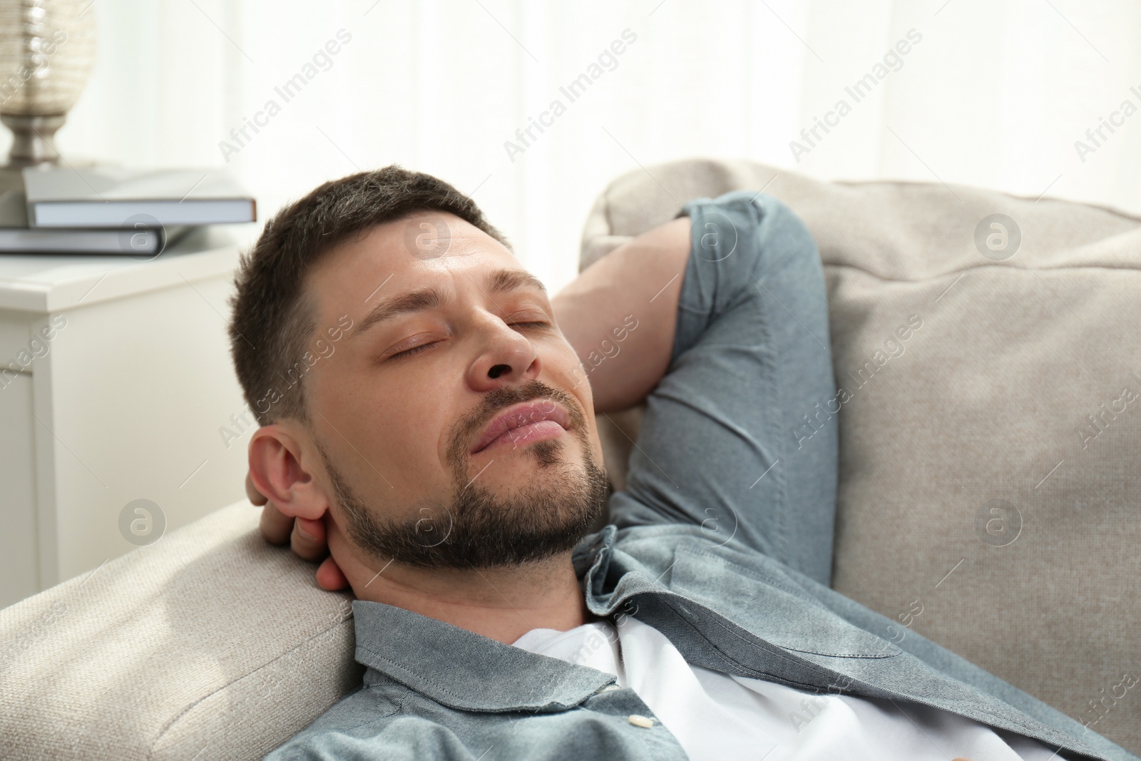 Photo of Handsome man sleeping on sofa at home