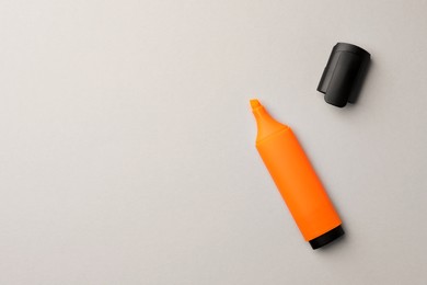 Photo of Bright orange marker on light grey background, flat lay. Space for text