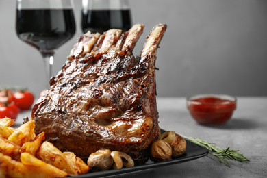 Photo of Delicious grilled ribs served on light grey table