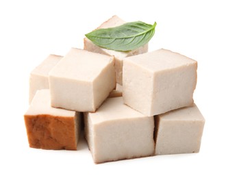 Photo of Pile of smoked tofu cubes and basil on white background