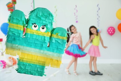 Bright festive pinata hanging indoors at birthday party, space for text