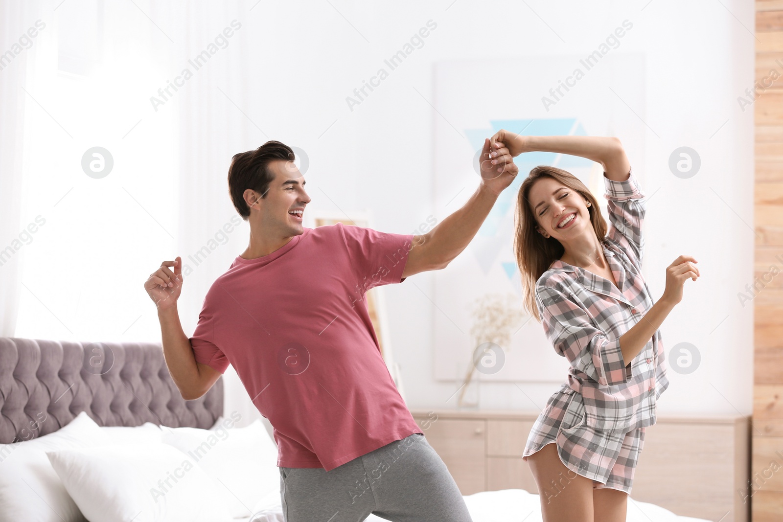 Photo of Beautiful young couple dancing in bedroom at home