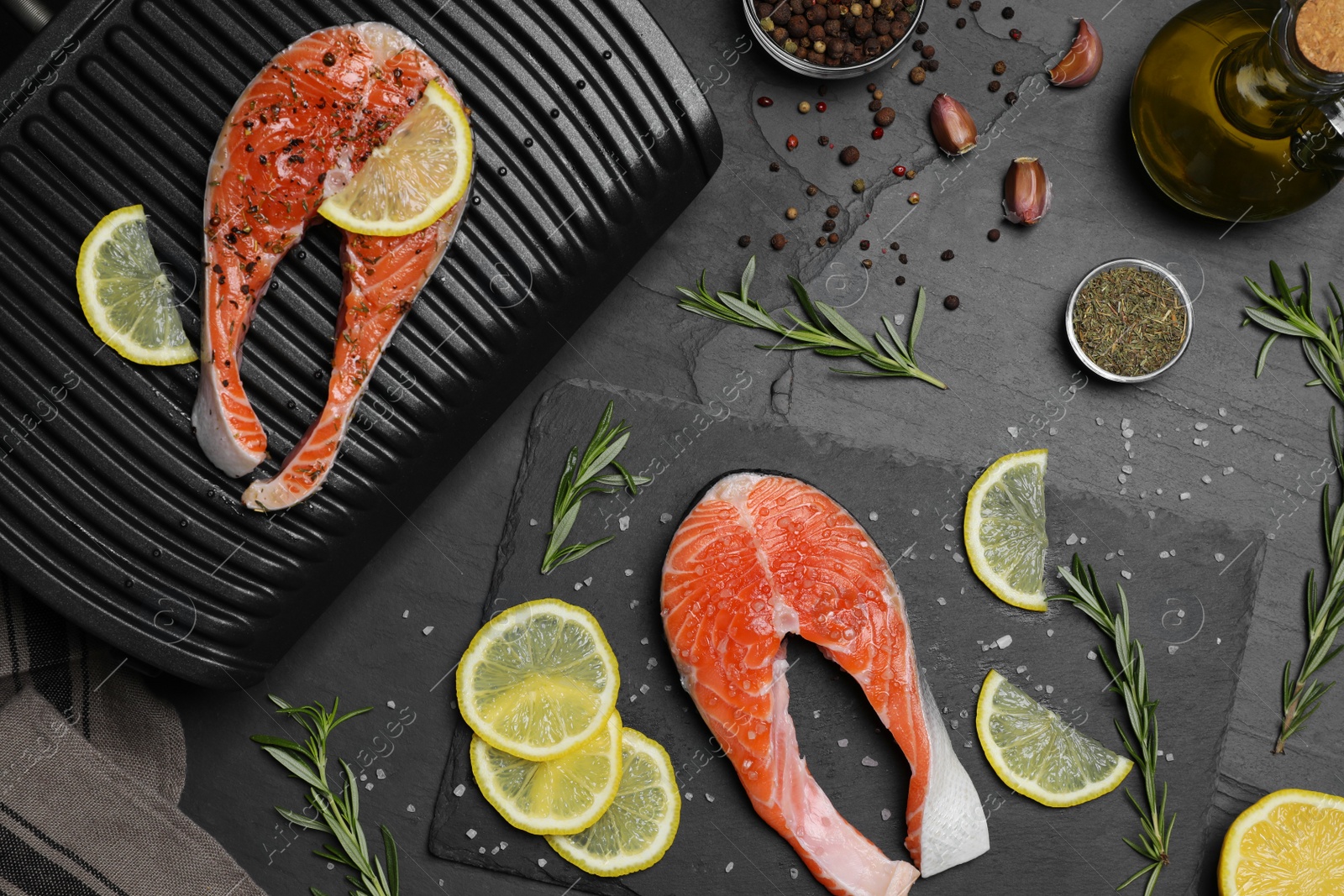 Photo of Cooking salmon. Grill, fresh fish steaks, lemon and spices on dark table, flat lay