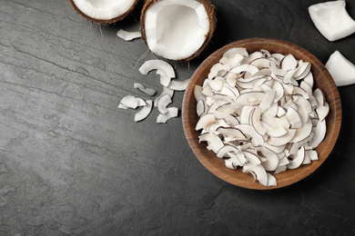 Photo of Flat lay composition with tasty coconut chips on black  table