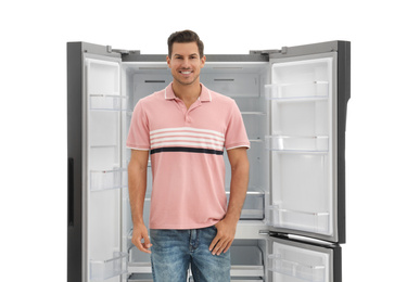 Photo of Man near empty refrigerator on white background
