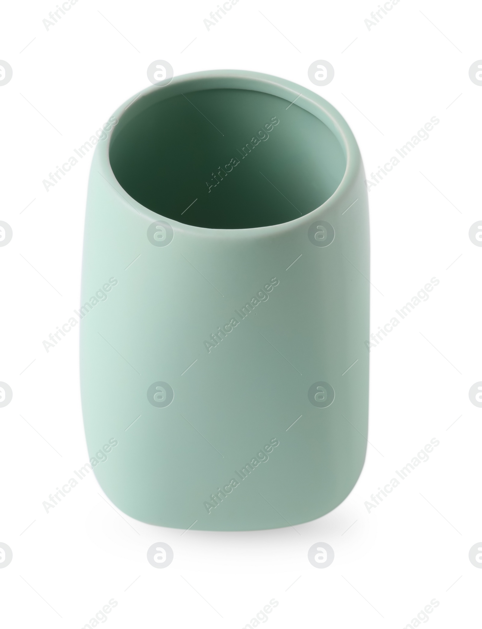 Photo of Bath accessory. Light green ceramic toothbrush holder isolated on white