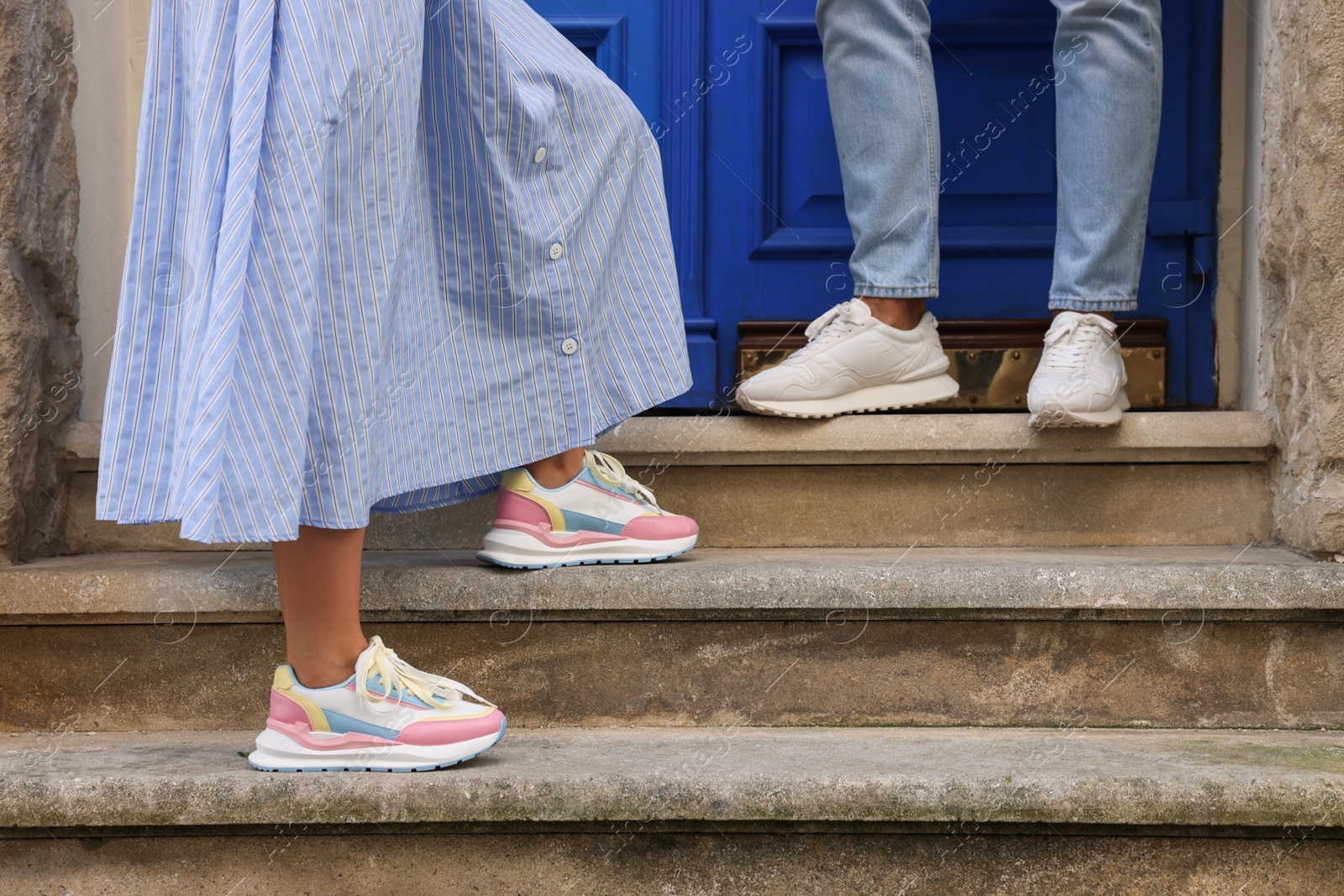 Photo of Woman and man wearing stylish sneakers on stairs outdoors closeup