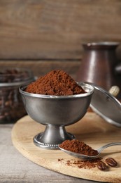 Photo of Ground coffee and beans on wooden table