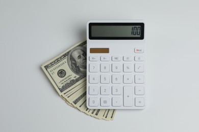Money exchange. Dollar banknotes and calculator on white background, top view