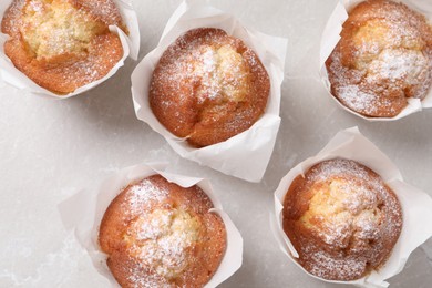 Delicious muffins on light table, flat lay