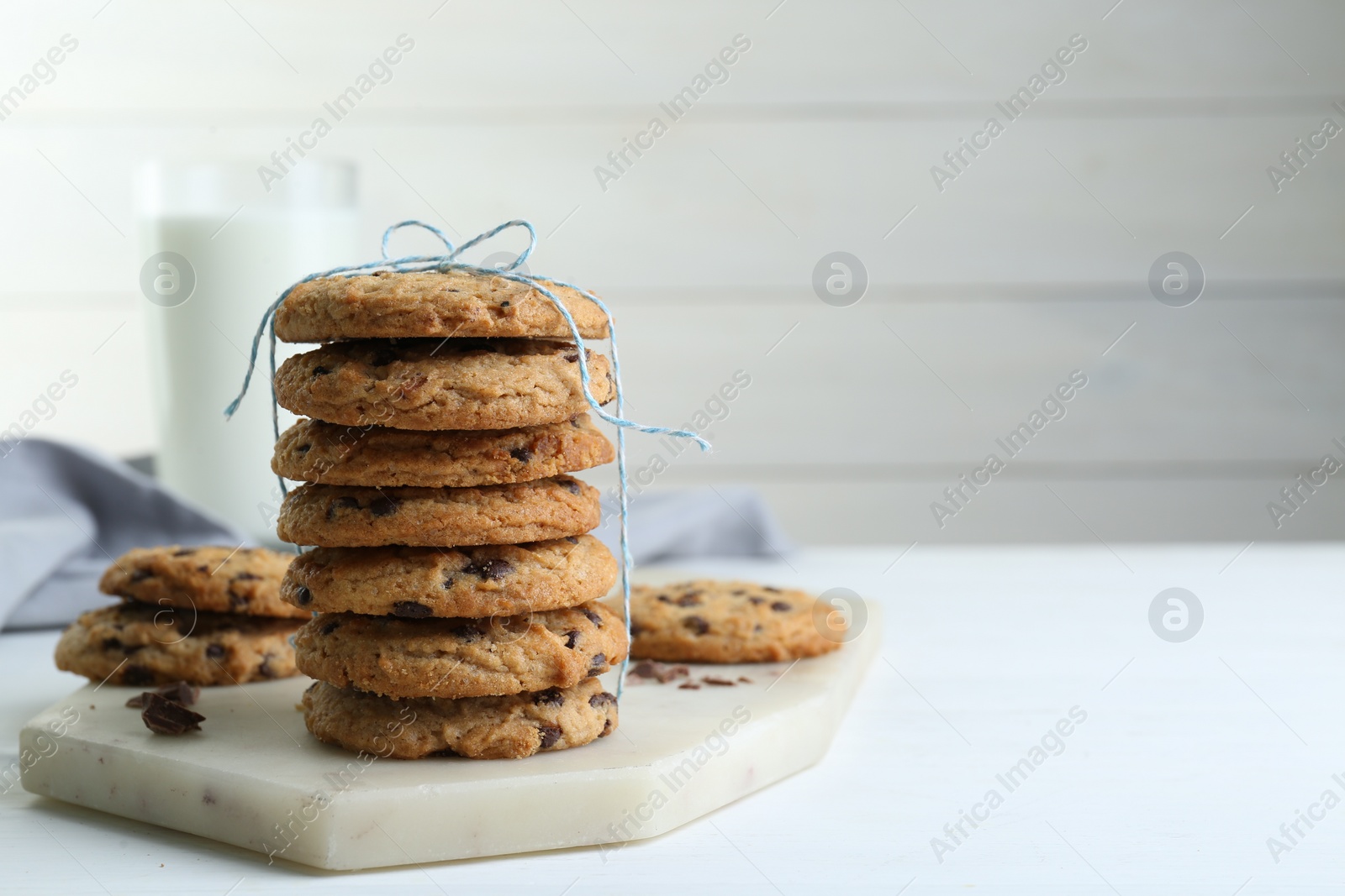 Photo of Tasty chocolate chip cookies on white wooden table, closeup. Space for text