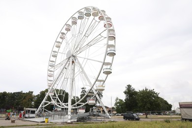 Photo of DARLOWO, POLAND - AUGUST 22, 2022: Large white observation wheel in amusement park