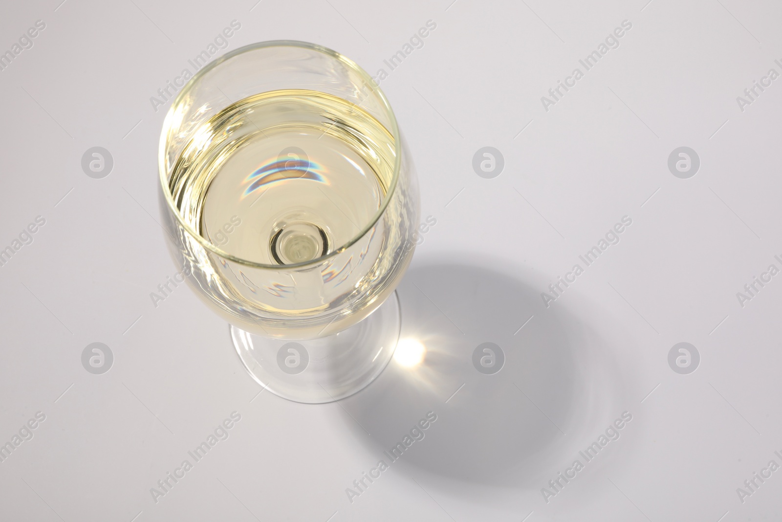 Photo of Tasty aromatic wine in glass isolated on white, above view