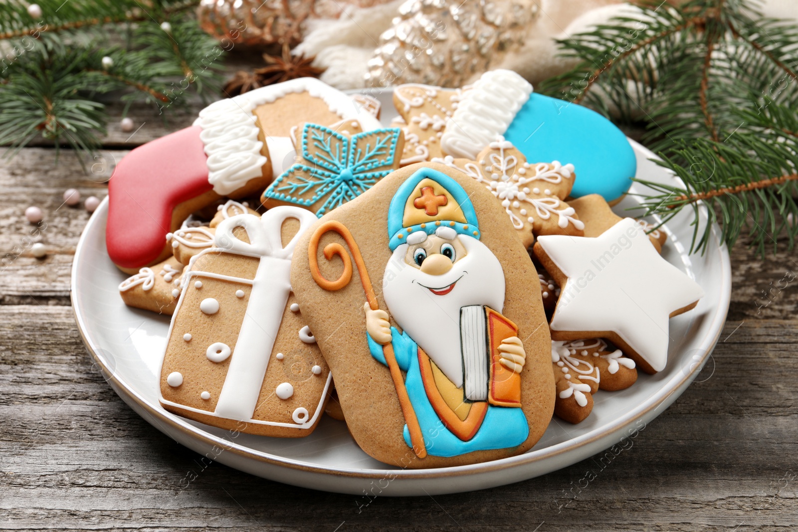 Photo of Tasty gingerbread cookies on wooden table, closeup. St. Nicholas Day celebration