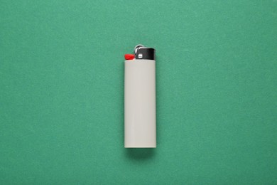 Photo of Stylish small pocket lighter on green background, top view