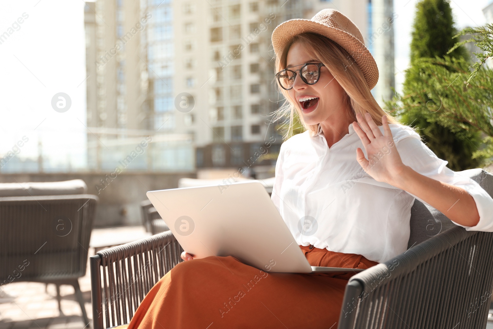 Photo of Beautiful woman using laptop at outdoor cafe