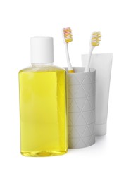 Photo of Bottle of mouthwash, toothbrushes and toothpaste isolated on white