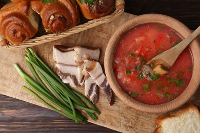 Delicious borsch served with pampushky and salo on wooden table, top view. Traditional Ukrainian cuisine