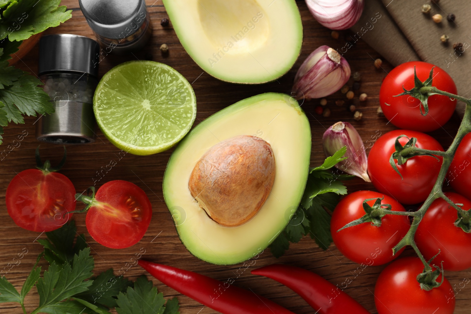 Photo of Fresh ingredients for guacamole on wooden table, flat lay