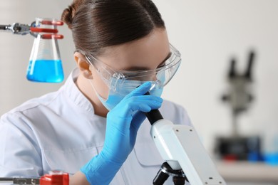 Photo of Young scientist working with microscope in laboratory