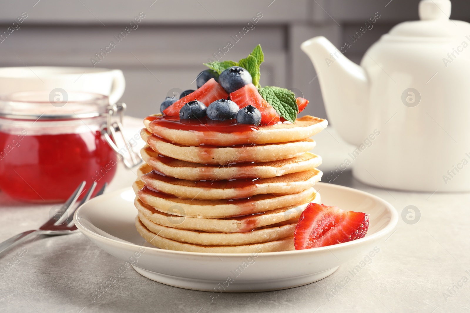 Photo of Plate with pancakes and berries on table