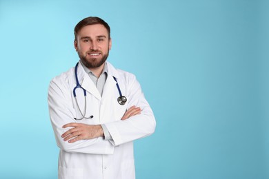 Pediatrician with stethoscope on light blue background, space for text