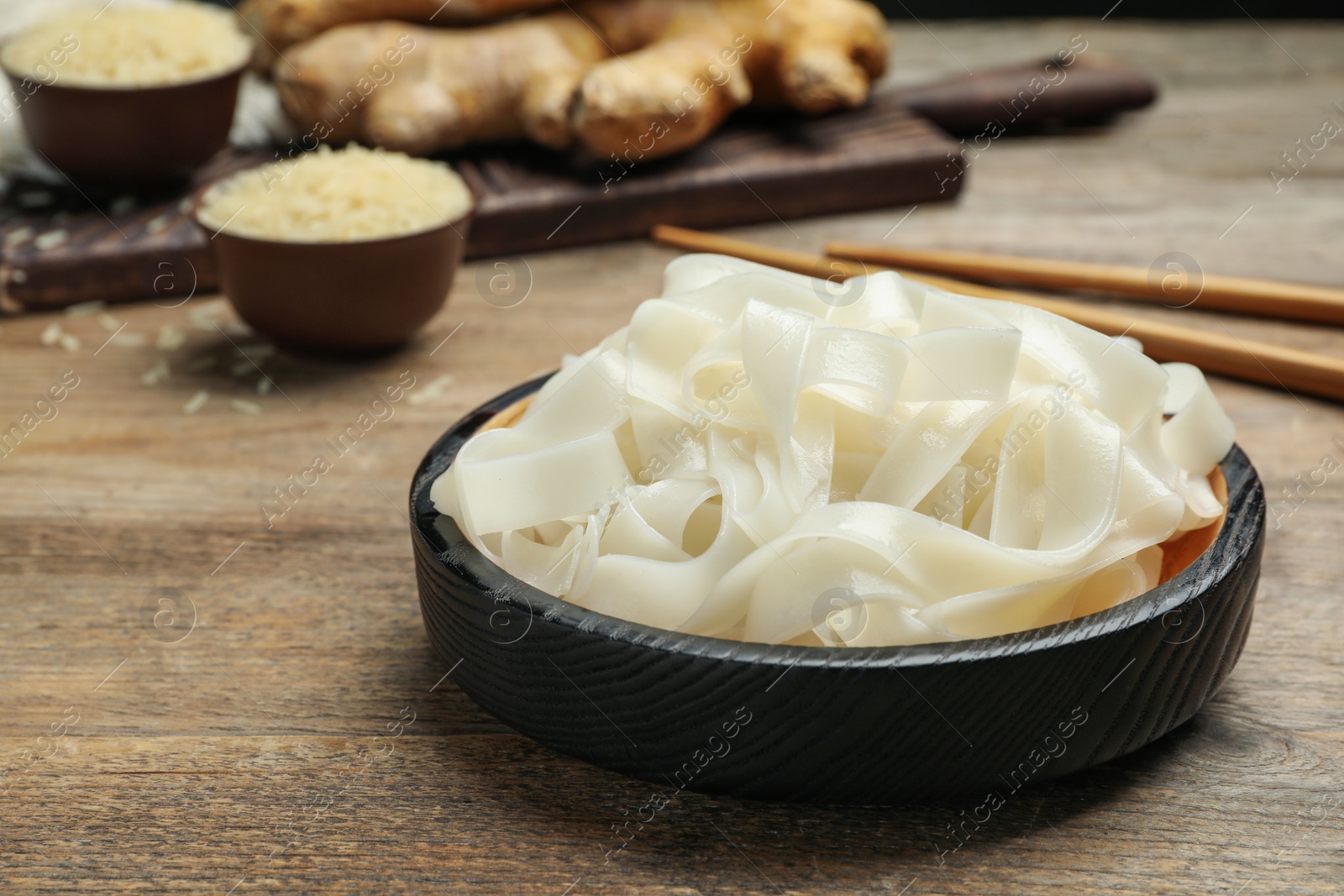 Photo of Tasty rice noodles on wooden table, closeup