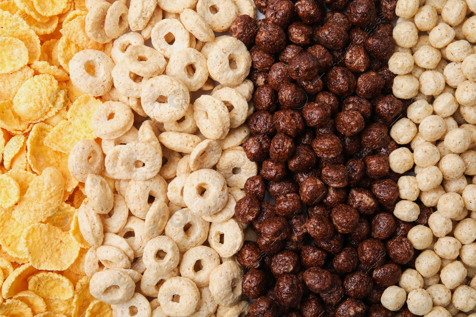 Photo of Different types of breakfast cereals as background, top view