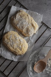 Photo of Raw dough for ciabatta and flour on grey table, flat lay
