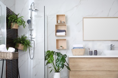 Photo of Bathroom interior with shower stall, counter and houseplants. Idea for design