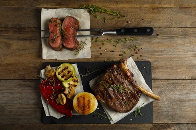 Photo of Flat lay composition with grilled meat on wooden table