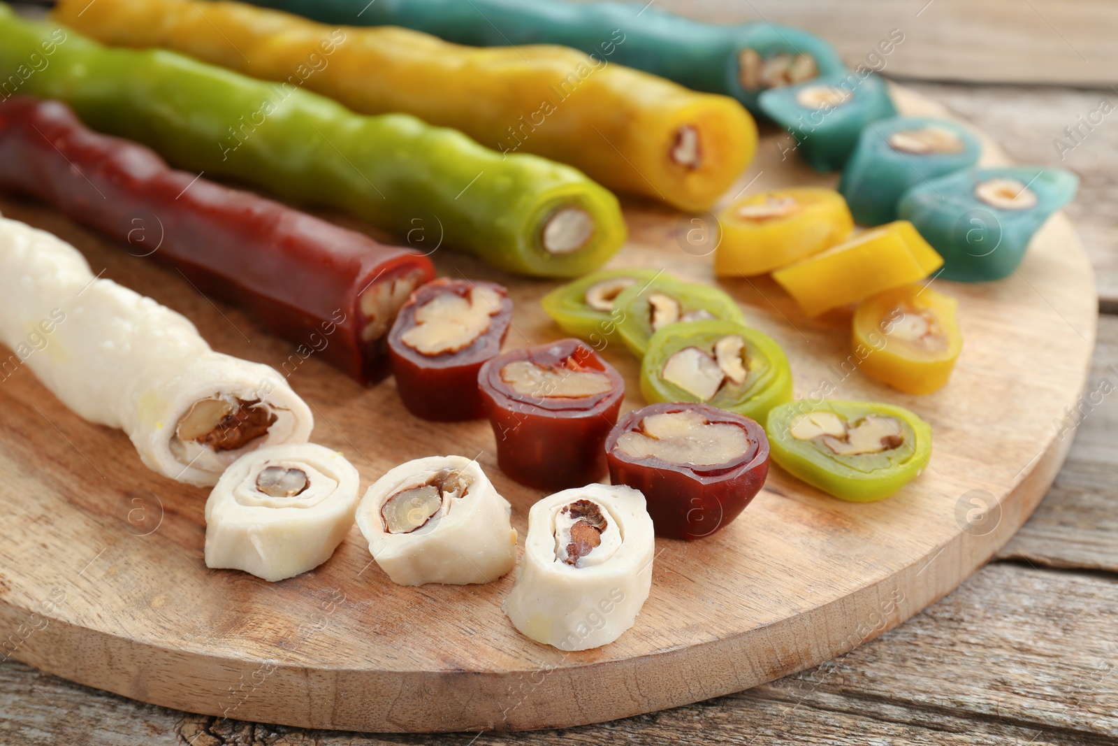 Photo of Delicious sweet churchkhelas on wooden table, closeup