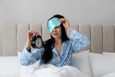 Overslept woman with alarm clock in bed. Being late concept