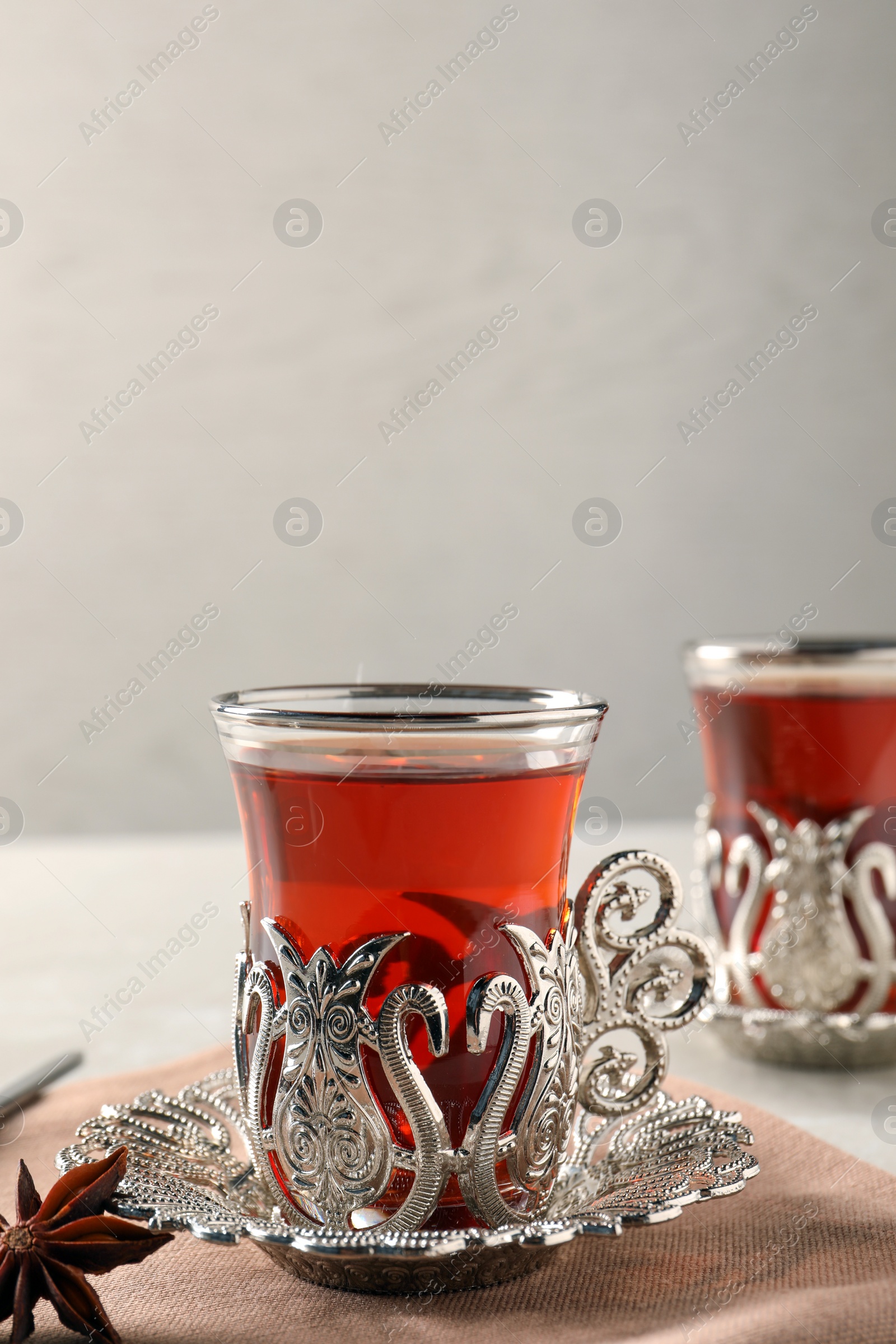 Photo of Glasses of traditional Turkish tea in vintage holders on table